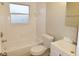 Neat, bright bathroom with white fixtures, a shower-tub combination, and a window for natural light at 9062 Sunrise Dr, Largo, FL 33773
