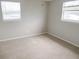 Bedroom features neutral walls, two windows, and light colored carpet at 9062 Sunrise Dr, Largo, FL 33773
