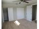 Bedroom with two closets, ceiling fan, and light colored carpeting at 9062 Sunrise Dr, Largo, FL 33773