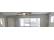 Open living room features a large window, a ceiling fan with lights, and white trim throughout at 9062 Sunrise Dr, Largo, FL 33773