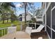 Relaxing back porch setting with table, chairs, and a lounge chair overlooking the lawn at 9770 Indian Key Trl # 102, Seminole, FL 33776