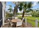 Beautiful outdoor space with a wooden table, chairs, lush plants, and landscaping at 9770 Indian Key Trl # 102, Seminole, FL 33776