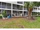 View of back patios and decks of units with lush green yard from ground level at 9770 Indian Key Trl # 102, Seminole, FL 33776