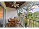 Outdoor balcony with table and chairs, ceiling fan, and view of tropical greenery at 9770 Indian Key Trl # 102, Seminole, FL 33776