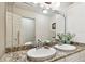 Bathroom with double sinks, granite counters, and a large framed mirror at 9770 Indian Key Trl # 102, Seminole, FL 33776