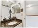Well-lit bathroom with granite counters, modern fixtures, and a view of the shower at 9770 Indian Key Trl # 102, Seminole, FL 33776