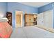 Blue bedroom with a glimpse into the attached bathroom and a wooden wardrobe at 9770 Indian Key Trl # 102, Seminole, FL 33776