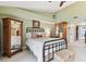 Well-lit bedroom featuring a black metal bed frame, light green walls and matching carpet at 9770 Indian Key Trl # 102, Seminole, FL 33776