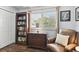 Cozy bedroom nook with a bookshelf, dresser, comfortable chair, and natural light at 9770 Indian Key Trl # 102, Seminole, FL 33776