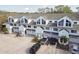Row of townhomes with white exteriors, attached garages, well-manicured landscaping, and ample parking space at 9770 Indian Key Trl # 102, Seminole, FL 33776