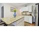 Bright eat-in kitchen featuring granite counters, stainless steel appliances, and white cabinets at 9770 Indian Key Trl # 102, Seminole, FL 33776