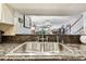 Double stainless kitchen sink with dark countertop overlooks the dining and living area for easy conversation at 9770 Indian Key Trl # 102, Seminole, FL 33776