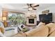 Comfortable living room with stone fireplace, flat screen television and access to screened-in porch at 9770 Indian Key Trl # 102, Seminole, FL 33776