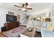 Comfortable living room featuring a sectional sofa, stairs to upper level, and view of the kitchen at 9770 Indian Key Trl # 102, Seminole, FL 33776