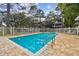 Community pool surrounded by white fence and mature trees, offering a refreshing outdoor space at 9770 Indian Key Trl # 102, Seminole, FL 33776