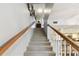 Carpeted staircase leading to the upper level of the home with natural wood handrail and white risers at 9770 Indian Key Trl # 102, Seminole, FL 33776