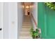 Well-lit staircase with carpeted steps and wooden railing at 9770 Indian Key Trl # 102, Seminole, FL 33776