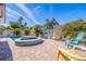 Beautiful pool and spa with brick pavers, palm trees and colorful lounge chairs under a blue sky at 10042 85Th St, Seminole, FL 33777