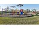 Community playground with colorful play equipment and shaded seating areas at 10347 Heron Hideaway Loop, Land O Lakes, FL 34638