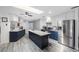 Modern kitchen featuring an island, stainless steel appliances, two-tone cabinets, and a bright skylight at 1036 Hamilton Ave, Tarpon Springs, FL 34689