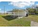View of the backyard, including a covered patio, a utility connection and sparse lawn at 106 W North Branch Rd, Ruskin, FL 33570