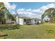 Well-maintained home with green lawn, attached garage, carport, and a glimpse of the backyard shed at 106 W North Branch Rd, Ruskin, FL 33570