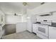 Bright kitchen showcasing an open layout with white appliances and tiled flooring at 106 W North Branch Rd, Ruskin, FL 33570