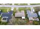 Aerial view of a single story home with a uniquely shaped roof, set amongst mature trees and manicured lawns at 119 Chesapeake Ave, Tampa, FL 33606