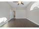 Living room with wood-look floors leading to a bathroom and featuring a ceiling fan at 12050 Stone Crossing Cir, Tampa, FL 33635