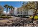 Well-maintained building exterior with covered parking, palm trees, and ample parking spaces at 1320 Pasadena S Ave # 605, South Pasadena, FL 33707