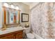 Cozy bathroom with a wood vanity, a framed mirror, and a shower with a patterned curtain at 13250 Ridge Rd # 10-4, Largo, FL 33778