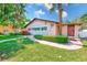 Charming exterior view with manicured lawn, a paved walkway and lush tropical landscaping at 13250 Ridge Rd # 10-4, Largo, FL 33778