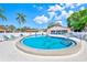 Community pool with inviting blue waters, surrounded by lounge chairs and palm trees at 13250 Ridge Rd # 10-4, Largo, FL 33778