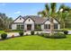 Stunning single-story home with manicured lawn, elegant landscaping, and a welcoming circular driveway at 13532 Haflinger Way, Hudson, FL 34667