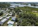 An aerial view of a home with a pool surrounded by mature trees and water at 14334 Channel Dr, Largo, FL 33774