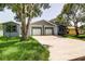 Exterior view of home featuring a two-car garage, new paint and green grass at 14334 Channel Dr, Largo, FL 33774