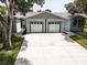 Exterior view of home featuring a two-car garage and well maintained lawn at 14334 Channel Dr, Largo, FL 33774