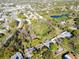 Aerial view of the neighborhood, surrounded by trees and a nearby pond at 1434 Glengarry Dr, Palm Harbor, FL 34684