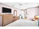Bedroom with woven dressers, ceiling fan, and access to en-suite bathroom at 1434 Glengarry Dr, Palm Harbor, FL 34684