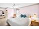 Cozy bedroom with pink walls, decorative accents, and soft lighting fixtures at 1434 Glengarry Dr, Palm Harbor, FL 34684