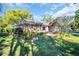 Beautifully landscaped front yard featuring mature trees and stone accents at 1434 Glengarry Dr, Palm Harbor, FL 34684