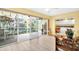 Cozy living room featuring a view of the screened lanai and a peek into the kitchen at 1434 Glengarry Dr, Palm Harbor, FL 34684