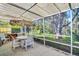 A screened lanai with an umbrella-covered table and seating at 1434 Glengarry Dr, Palm Harbor, FL 34684