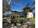 Rear patio with seating area and lush landscaping with a view of the home's exterior at 1535 Nursery Rd # 201, Clearwater, FL 33756