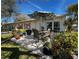 Back patio with dining furniture, an umbrella, and lush landscaping with a grill and storage bin at 1535 Nursery Rd # 201, Clearwater, FL 33756