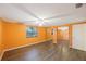 Bedroom featuring a ceiling fan, wood-look flooring, orange walls, and a mirrored closet at 15530 Morgan St, Clearwater, FL 33760