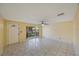 Bright living room with tile floors, a ceiling fan, and a front door entrance at 15530 Morgan St, Clearwater, FL 33760