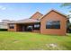 Home's back exterior view with a covered patio and well-maintained lawn at 15708 Oakleaf Run Dr, Lithia, FL 33547