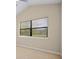 Bright bedroom featuring a window with blinds, neutral colored walls, and carpet flooring at 15708 Oakleaf Run Dr, Lithia, FL 33547