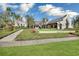 A clubhouse with white brick, manicured lawns, and lush landscaping at 15708 Oakleaf Run Dr, Lithia, FL 33547